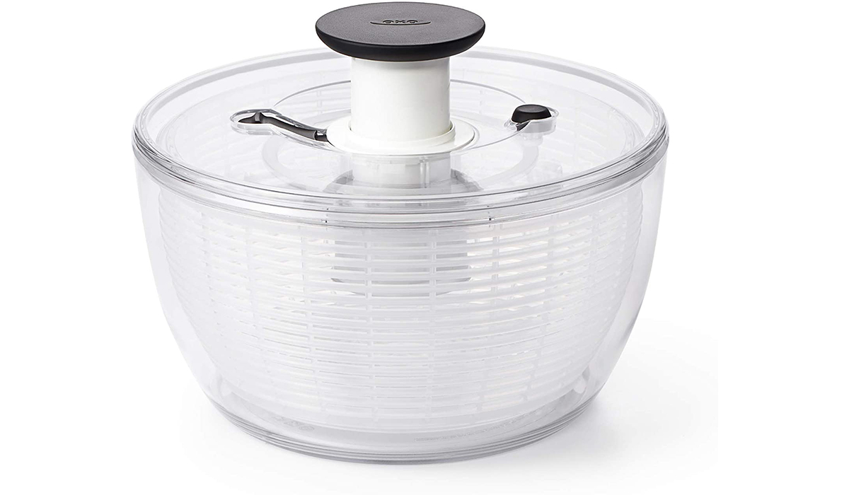 A clear salad spinner with a round top.