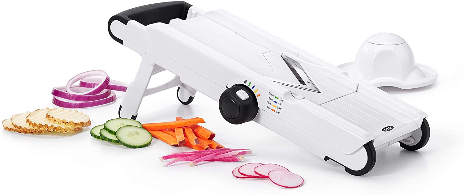 A mandoline slicer with a few different sliced vegetables